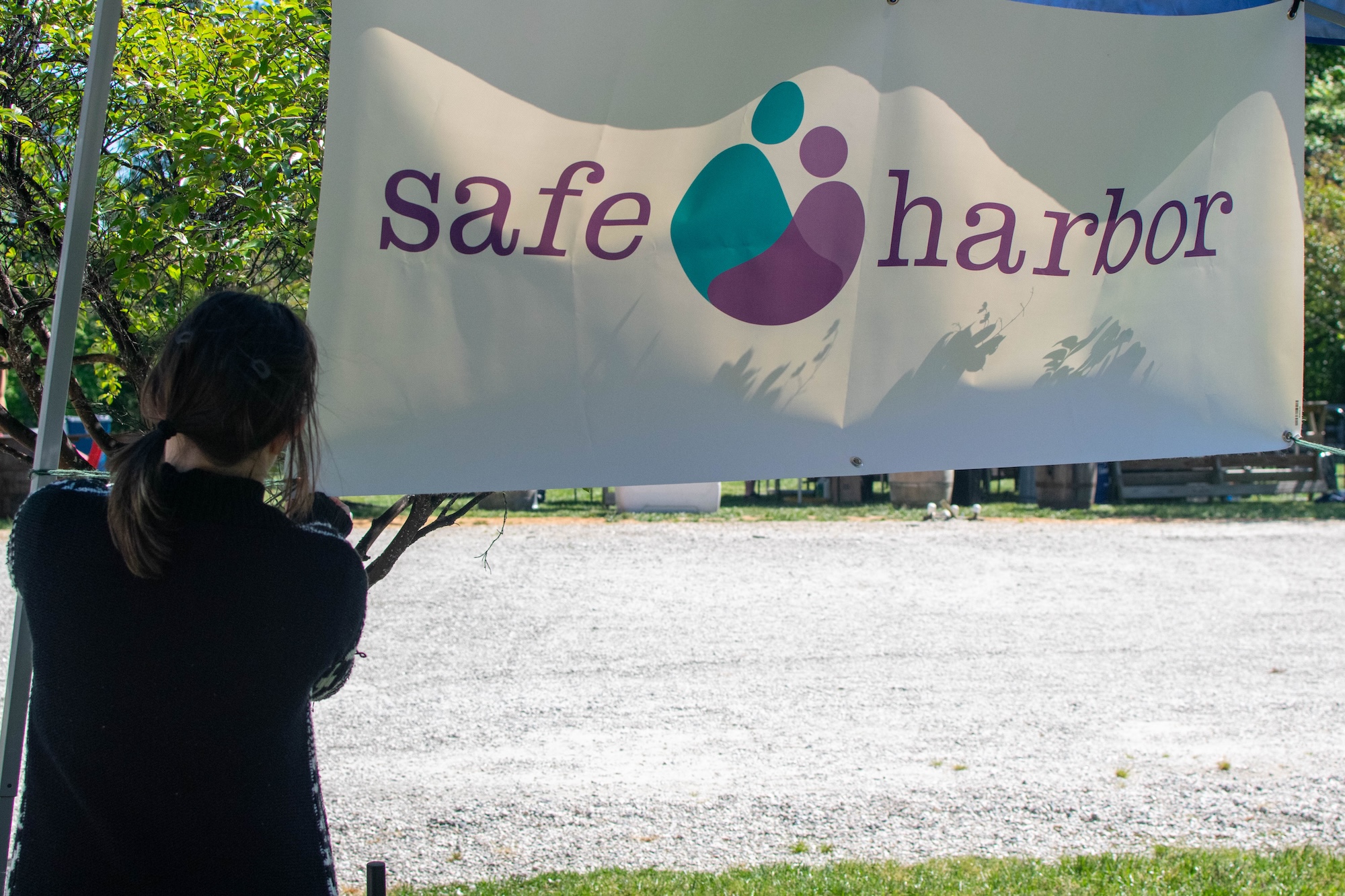 RVA Taco Festival 2026 - Volunteer hanging a Safe Harbor banner