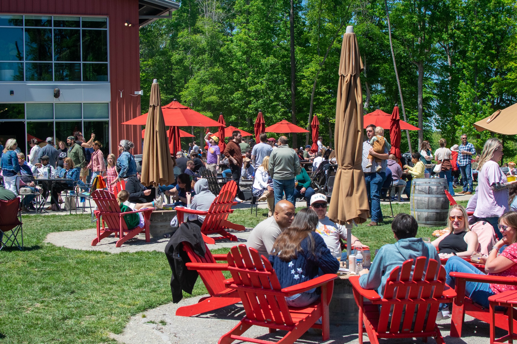 RVA Taco Festival 2026 - Attendees relaxing in red Adirondack chairs under umbrellas at Hardywood West Creek